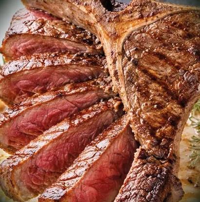 T-Bone Steak a la parrilla en corte fino, foto real de un plato del restaurante